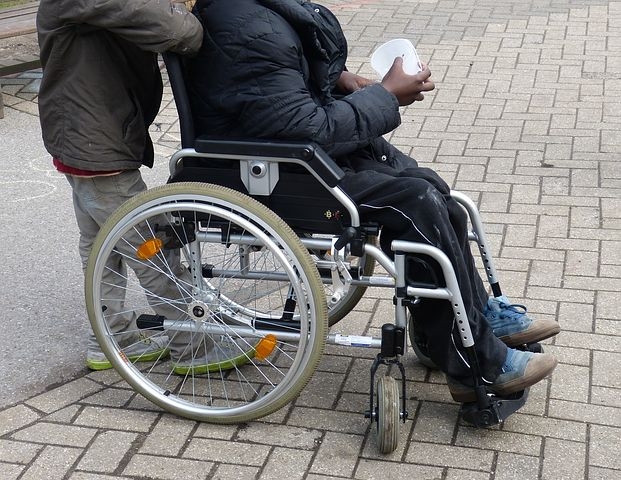 person in wheelchair with supporter